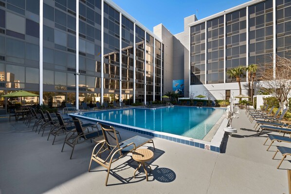 Una piscina al aire libre, camas de piscina gratis, sombrillas