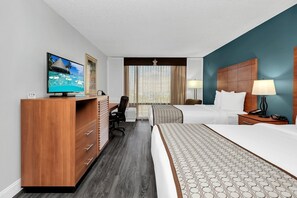 A hotel room with a bed, desk, chair, TV, and a view of the ocean through the window. - Best Western Orlando Gateway Hotel (Orlando)