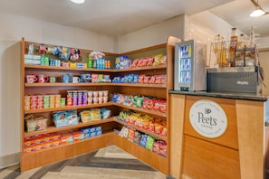 A Peet's Coffee shop with a variety of snacks and beverages on shelves and a refrigerator.
