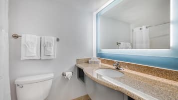 Un baño con inodoro, lavamanos y espejo.