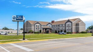 A Best Western Holiday Manor hotel with a large parking lot and a well-maintained lawn. - Best Western Holiday Manor (Newton)