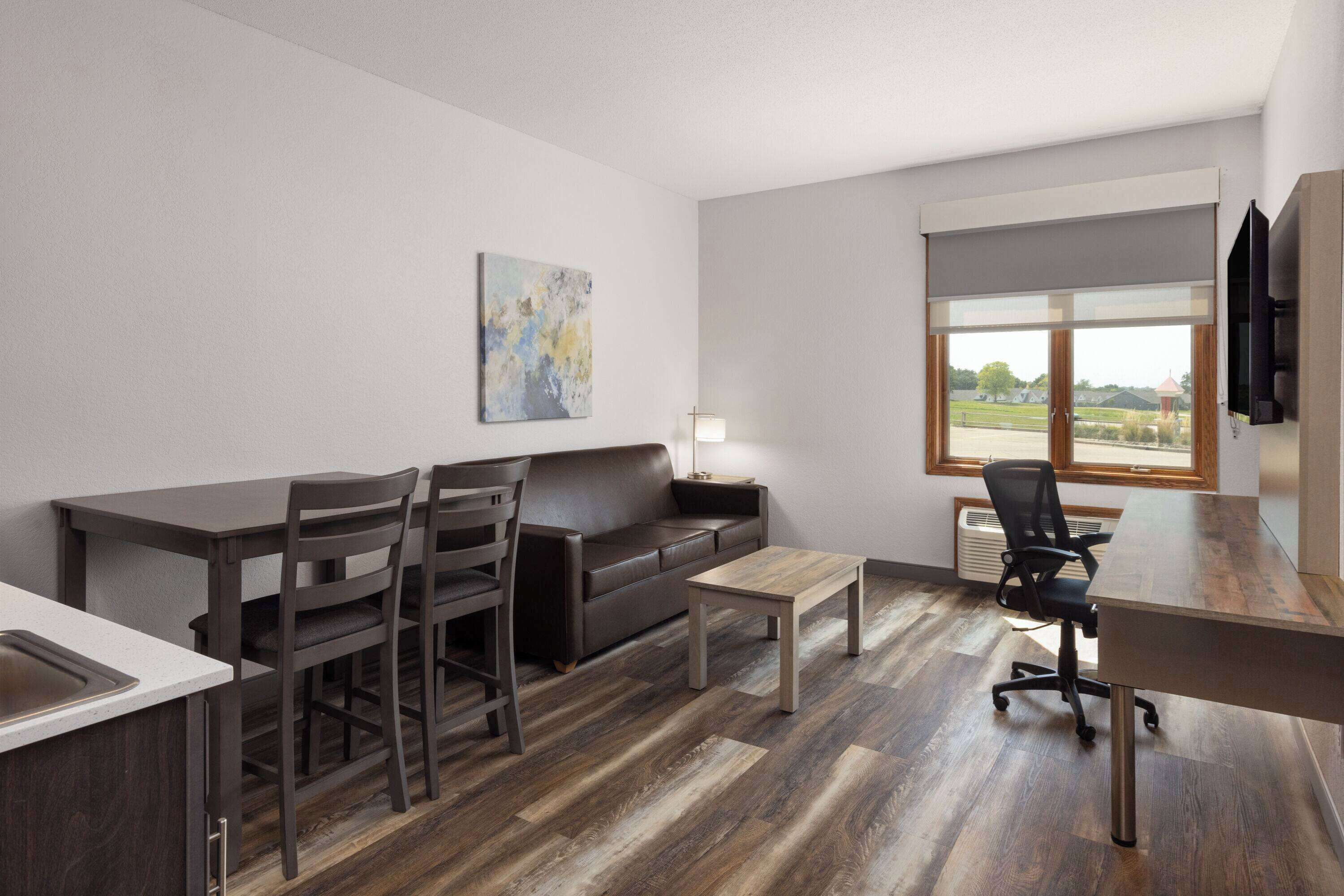 Una sala de estar moderna con sofá, mesa de comedor, sillas y una mesita de centro.