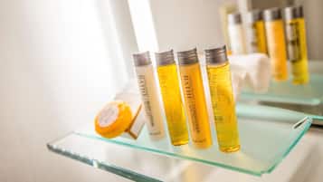 A bathroom shelf with various toiletries, including bottles of shampoo and conditioner.