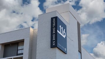 A hotel sign with the number 116 and the name "HOTEL ONE SIX" indicating the building's address.