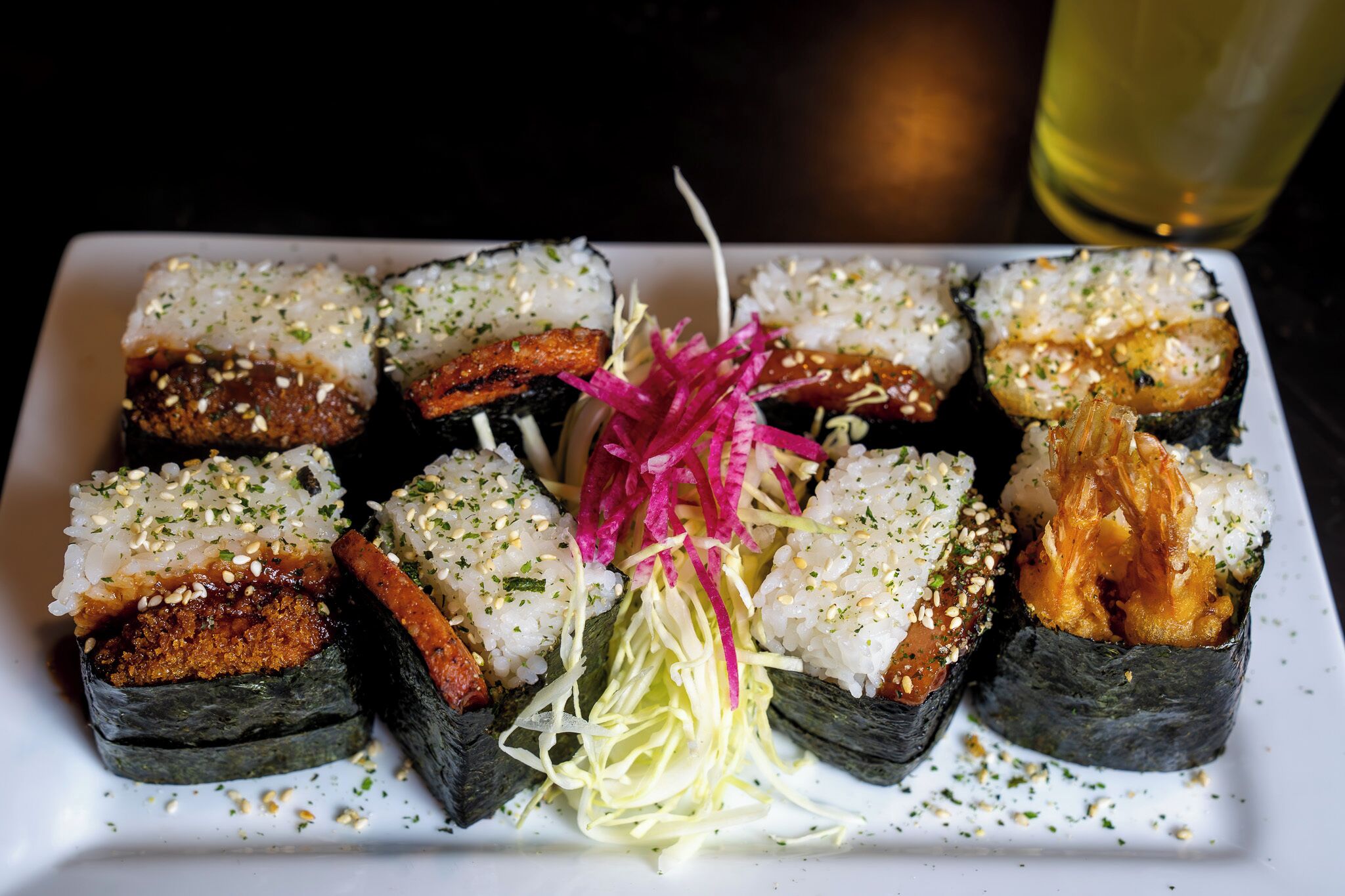 A plate of sushi with various toppings and garnishes.