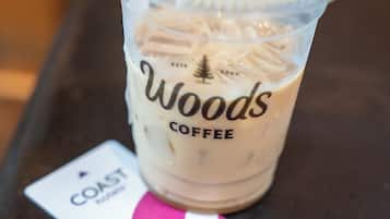 A clear plastic cup with a label reading "Woods Coffee" and a coaster underneath.