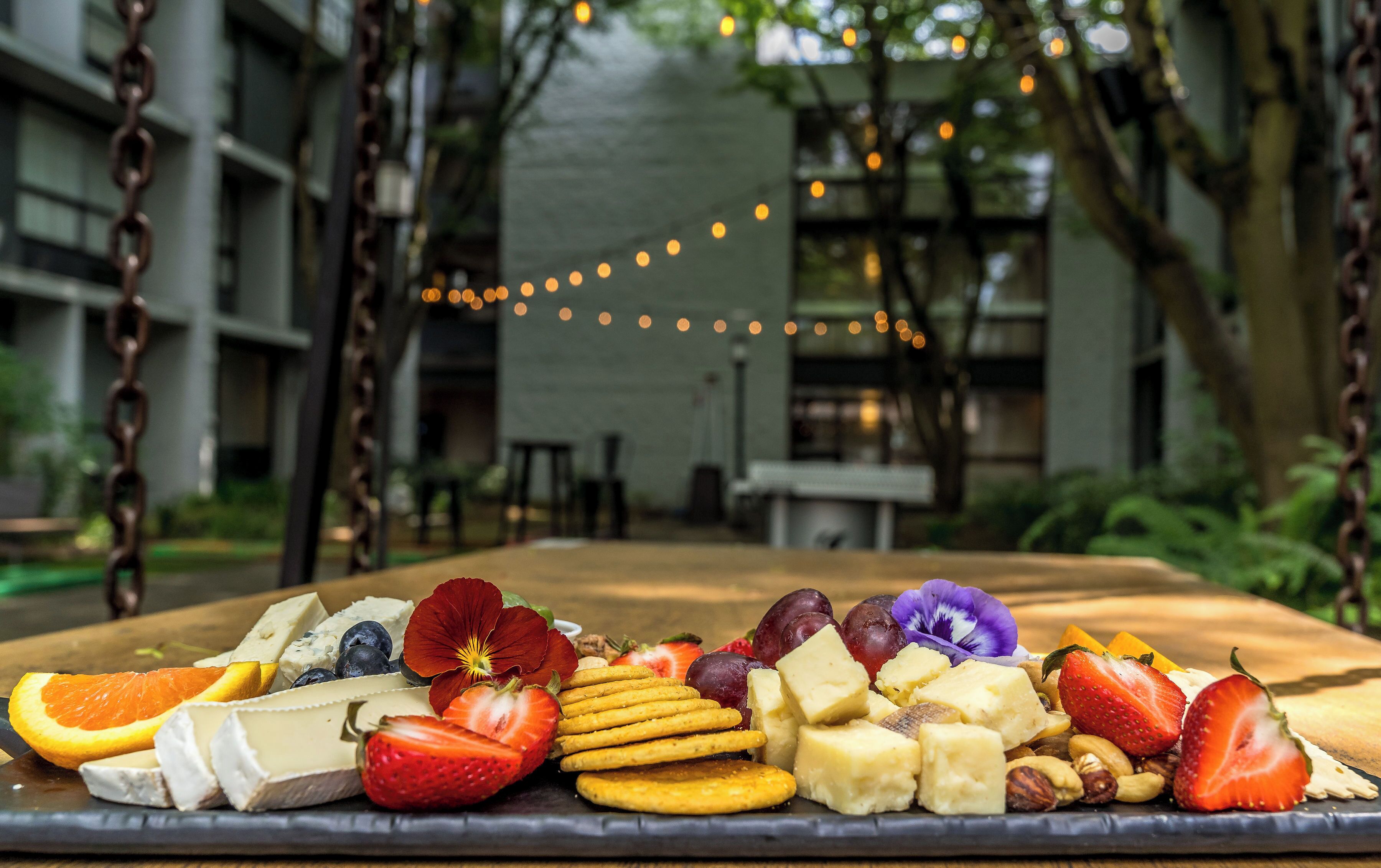 Una tabla de quesos con varios tipos de queso, frutas y frutos secos.