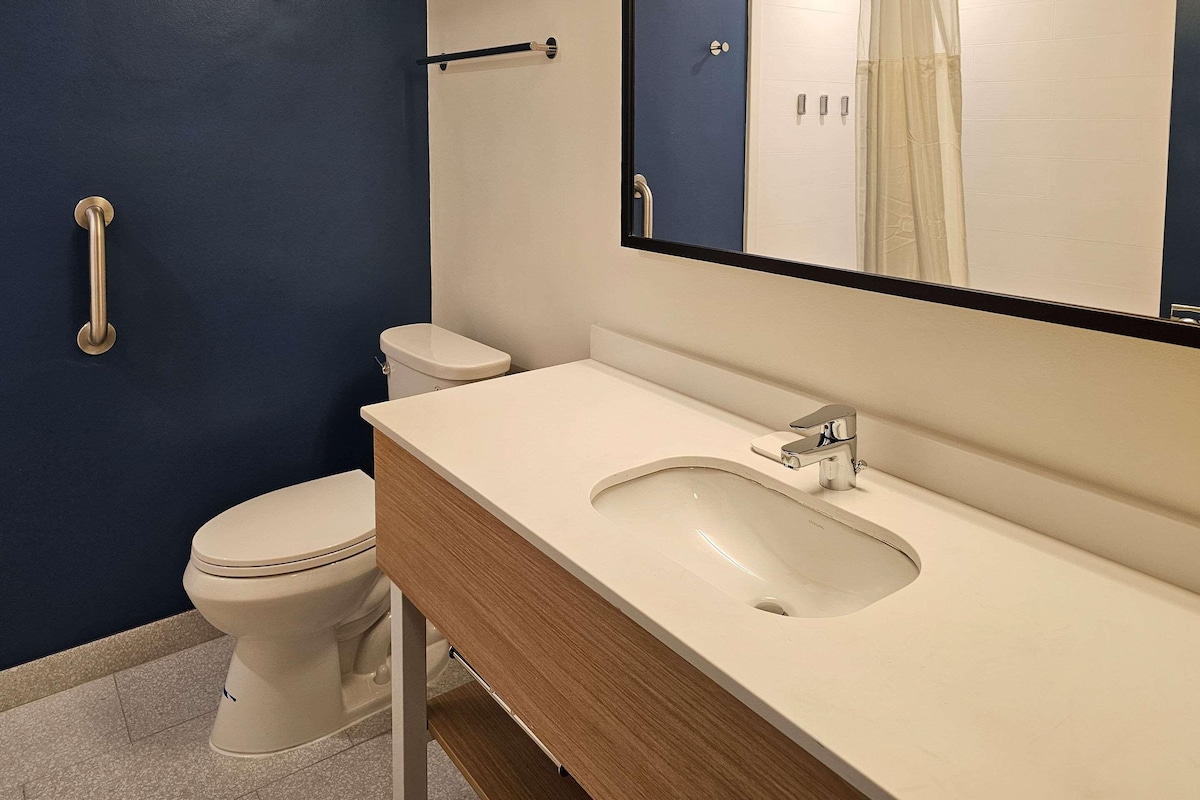 A bathroom with a toilet, a sink, and a mirror.