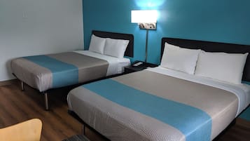 Une chambre d’hôtel avec deux lits, chacun recouvert d’une couverture bleue et beige, agrémentée d’oreillers blancs et dotée d’une table de chevet avec un téléphone.