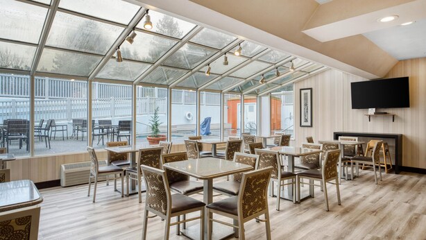 A spacious indoor dining area with large windows, tables, and chairs. - Best Western Alderwood (Lynnwood)
