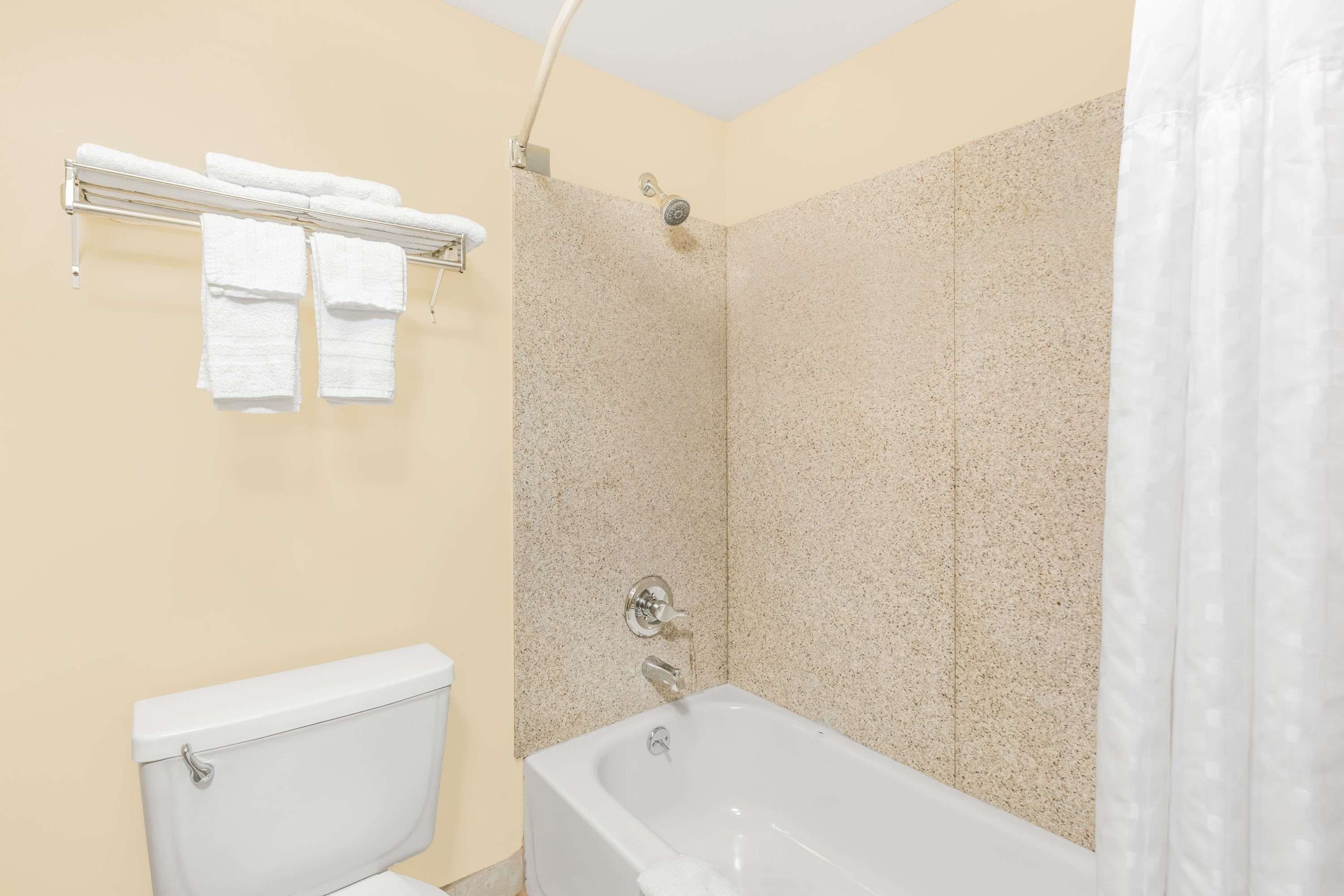 A bathroom with a bathtub, shower, and toilet.