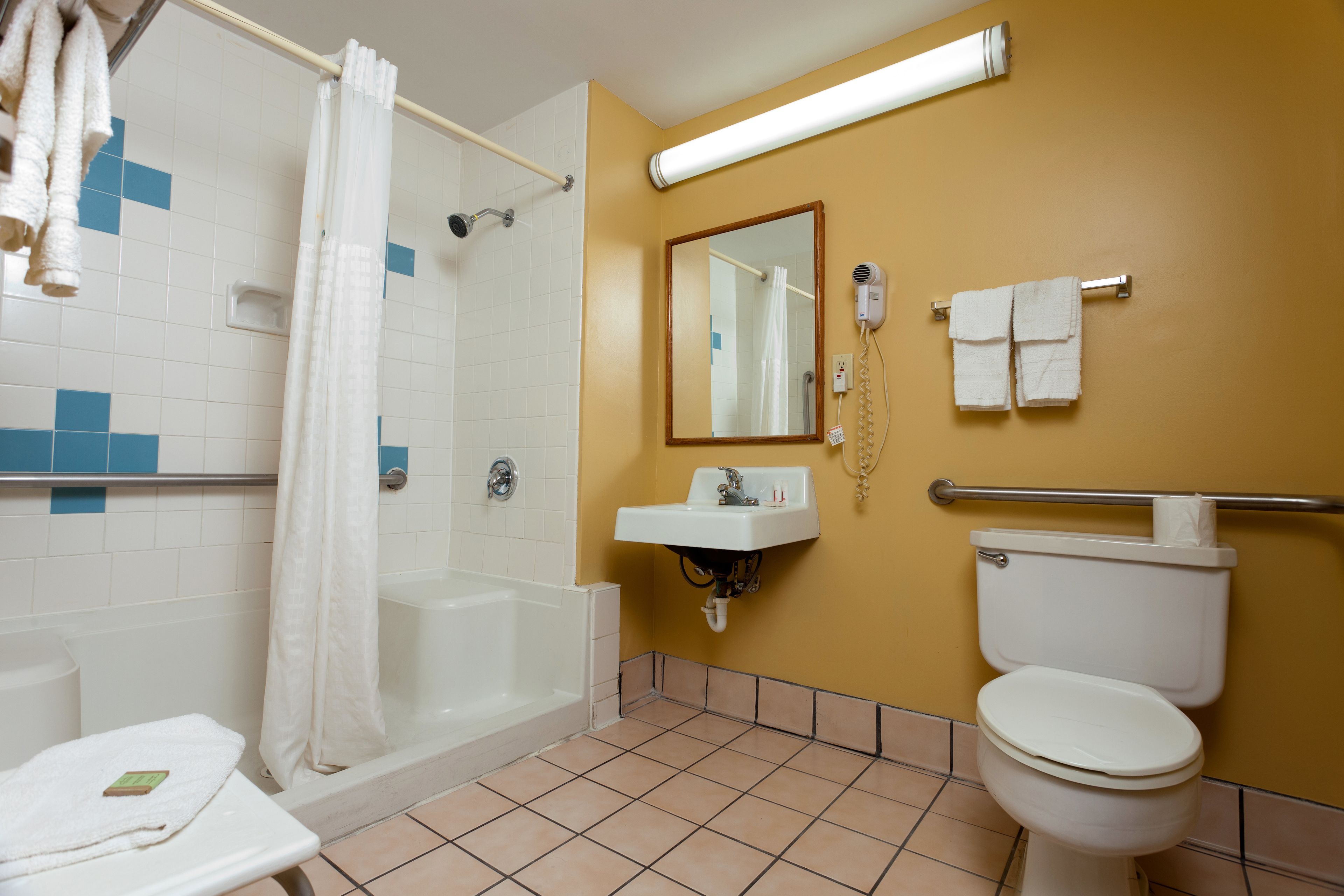 A bathroom with a bathtub, toilet, sink, and a shower curtain.