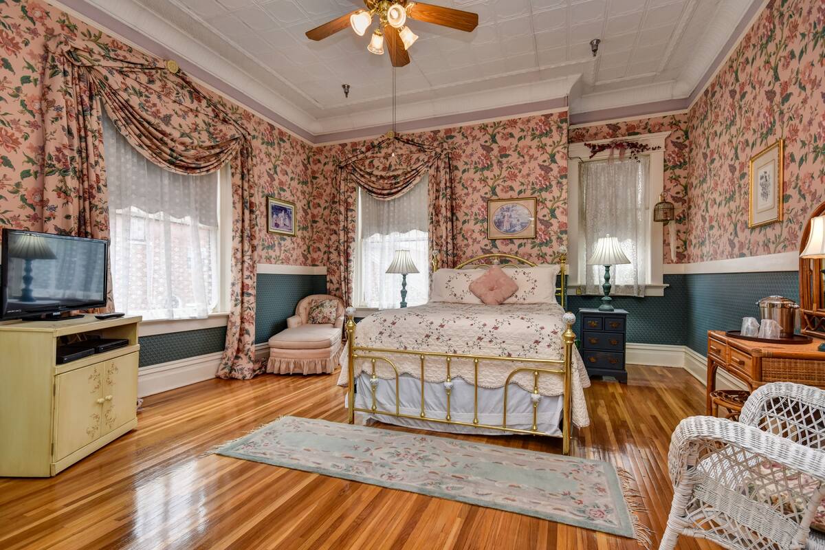 A bedroom with a bed, a television, a dresser, and a chair.