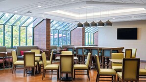 A spacious indoor dining area with high ceilings, large windows, and a variety of seating options including tables and chairs. - Hampton Inn Richland/Tri-Cities (Richland)