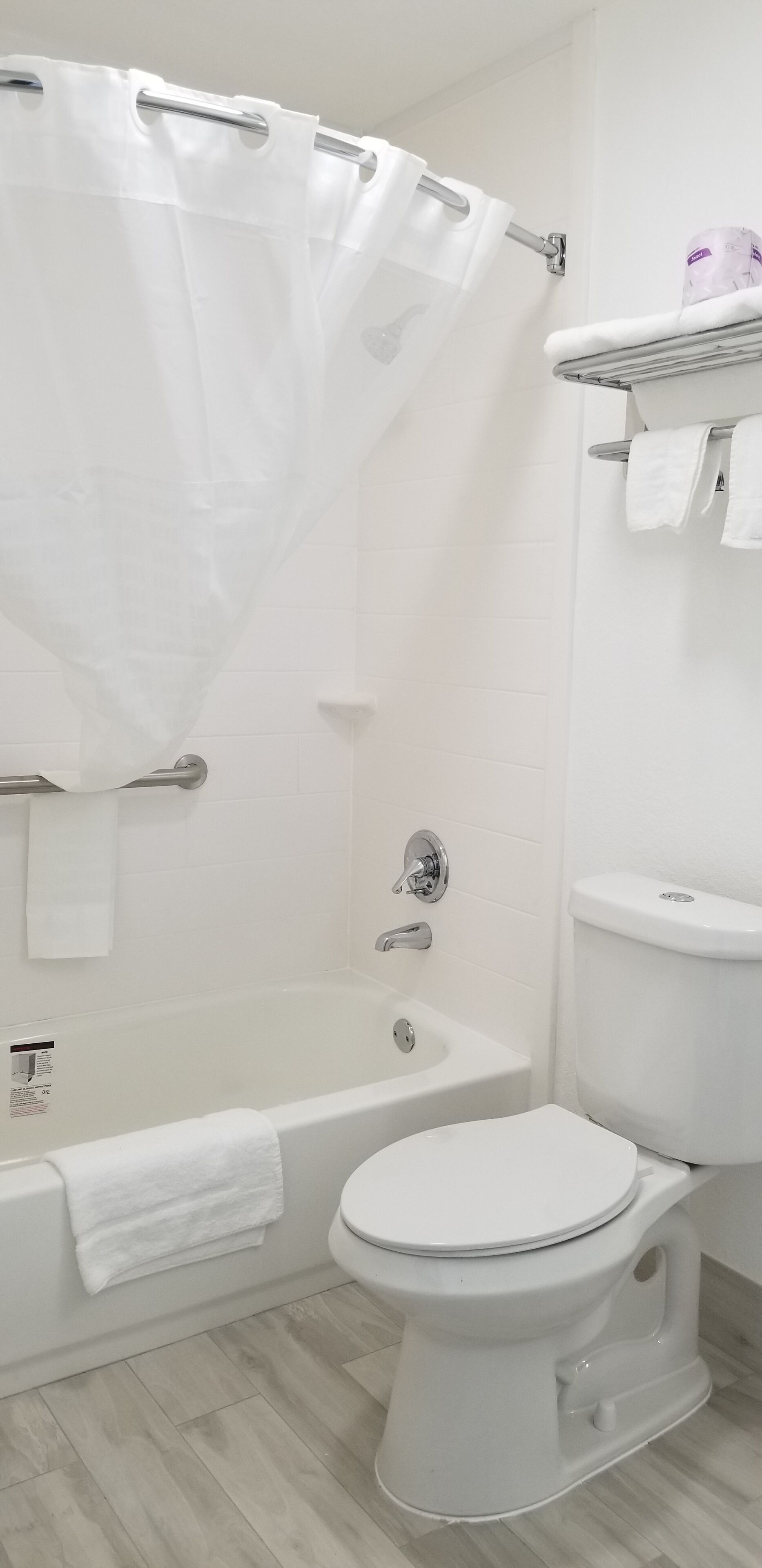 A bathroom with a bathtub, toilet, and a shower curtain.