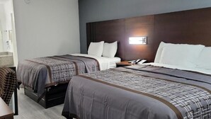 A hotel room with two beds, a desk, and a chair. - Key West Inn - Boaz (Boaz)