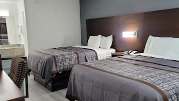 A hotel room with two beds, a desk, and a chair.