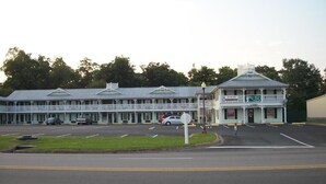 A motel with a central building and a smaller attached structure. - Key West Inn - Boaz (Boaz)