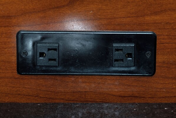 A black electrical outlet on a wooden surface. - Red Roof Inn Muscle Shoals (Muscle Shoals)