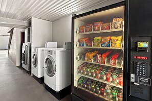 A laundromat with washers and dryers, and a vending machine stocked with snacks and drinks. - Red Roof Inn Muscle Shoals (Muscle Shoals)