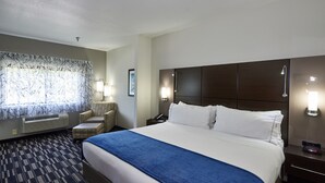 A hotel room with a large bed, a desk, a chair, and a window with a view. - Holiday Inn Express & Suites Birmingham South - Pelham by IHG (Pelham)
