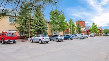 A parking lot with several cars and a red truck.