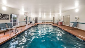 An indoor swimming pool with clear water, a 'No Diving' sign, and a lifeguard duty sign.
