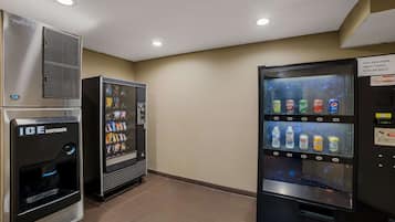 A vending machine area with an ice dispenser, a beverage vending machine, and a drink dispenser.