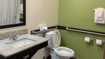 Un baño con lavamanos, inodoro y barandilla.