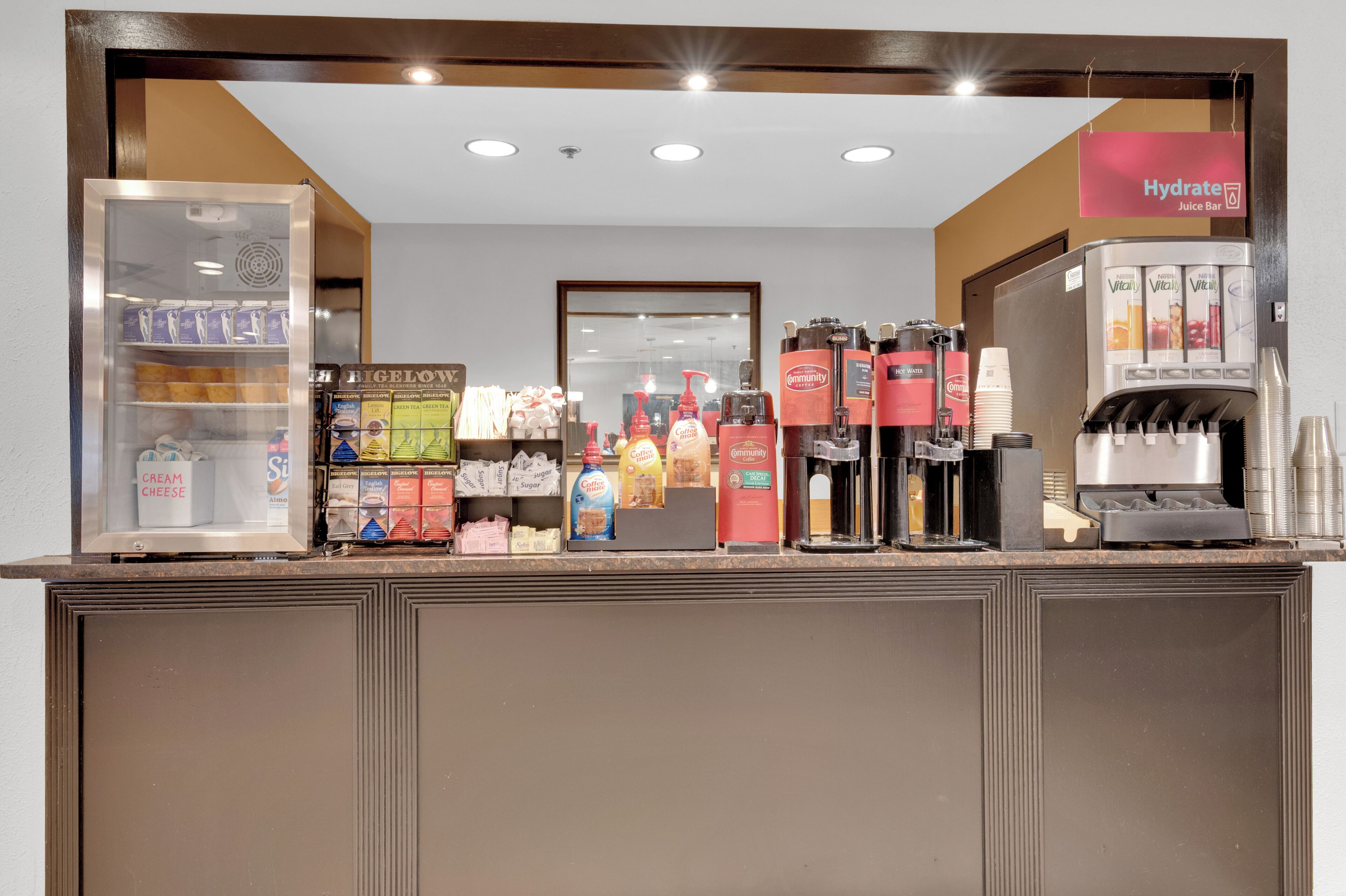 Un bar à jus avec un présentoir réfrigéré pour les boissons et un assortiment de collations.