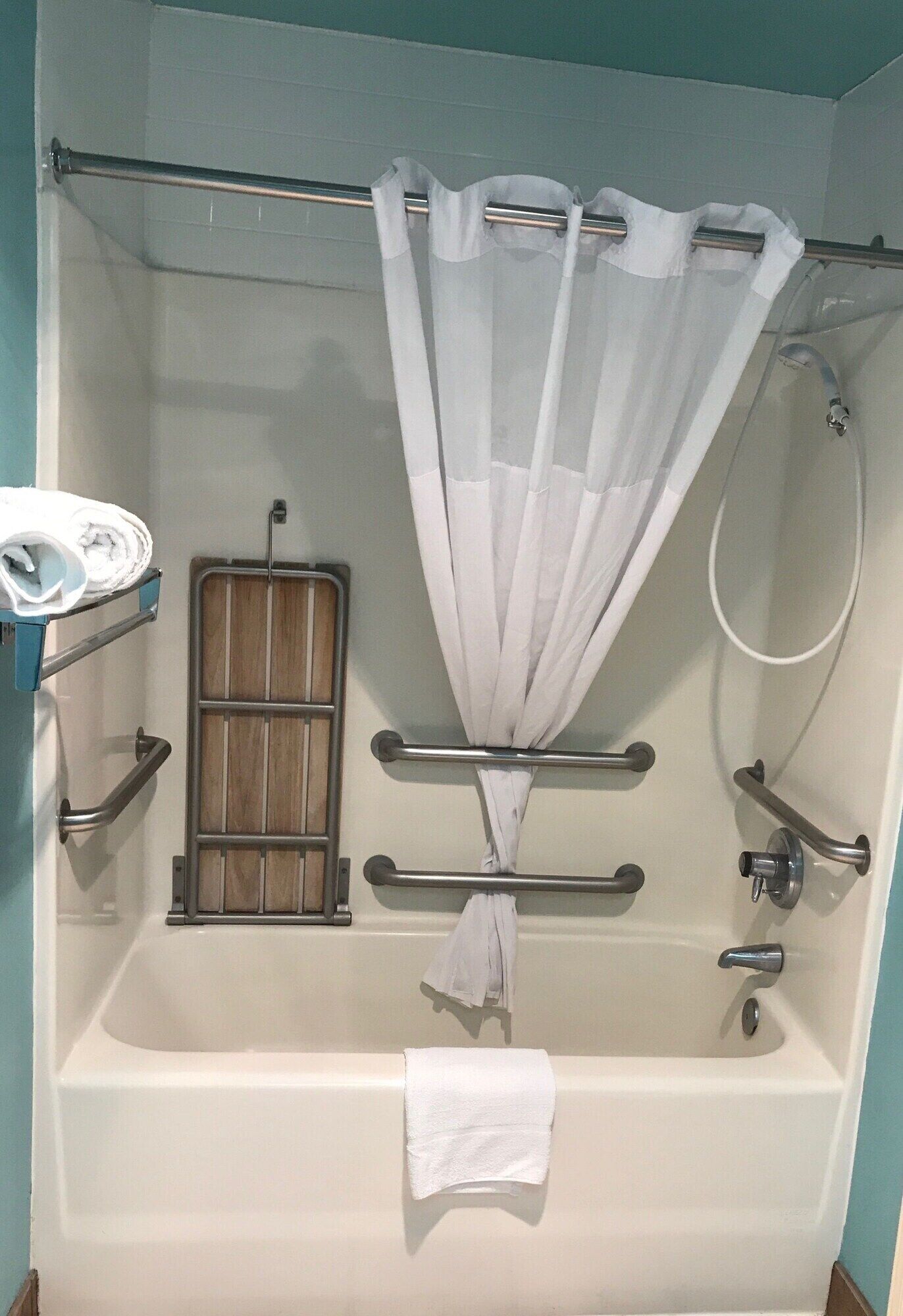 Un baño con bañera, ducha y un perchero para toallas.