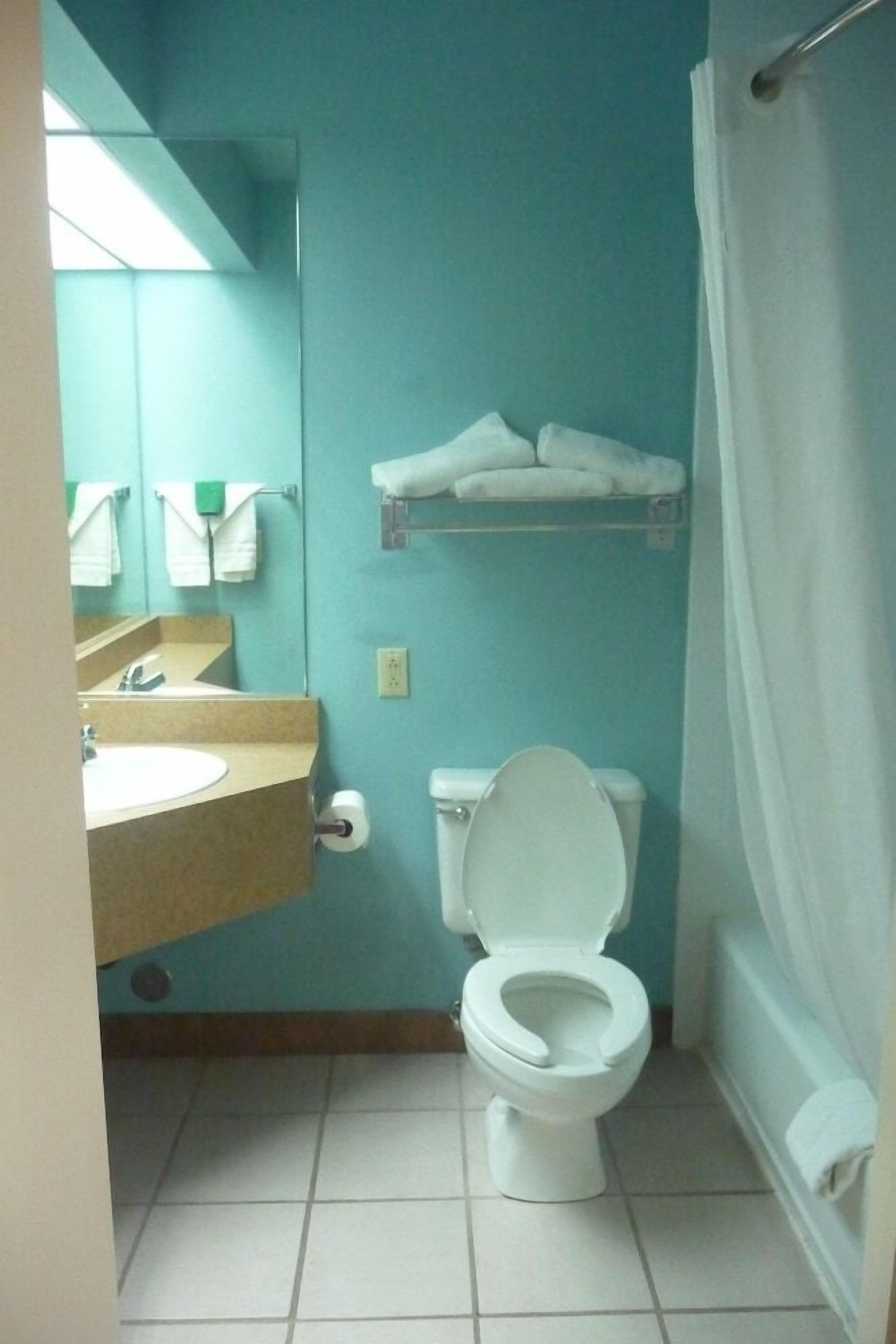 A small bathroom with a toilet, sink, and towel rack.