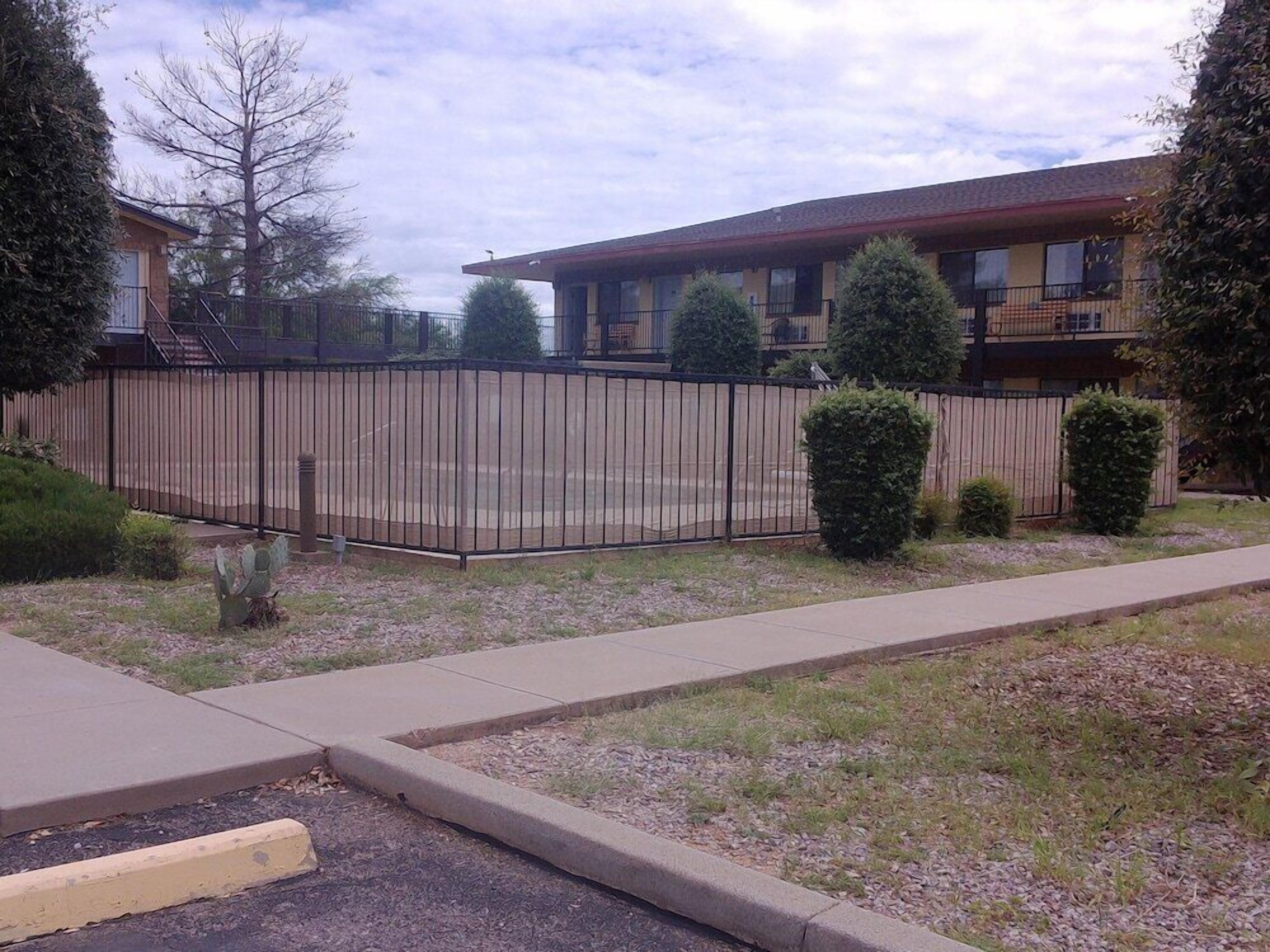 A fenced outdoor area with a building in the background.