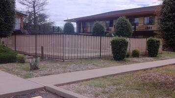 A fenced outdoor area with a building in the background.