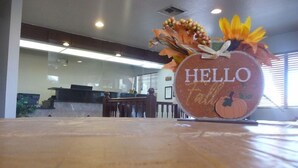 A reception area with a wooden reception desk, a 'HELLO' sign, and autumn-themed decorations.