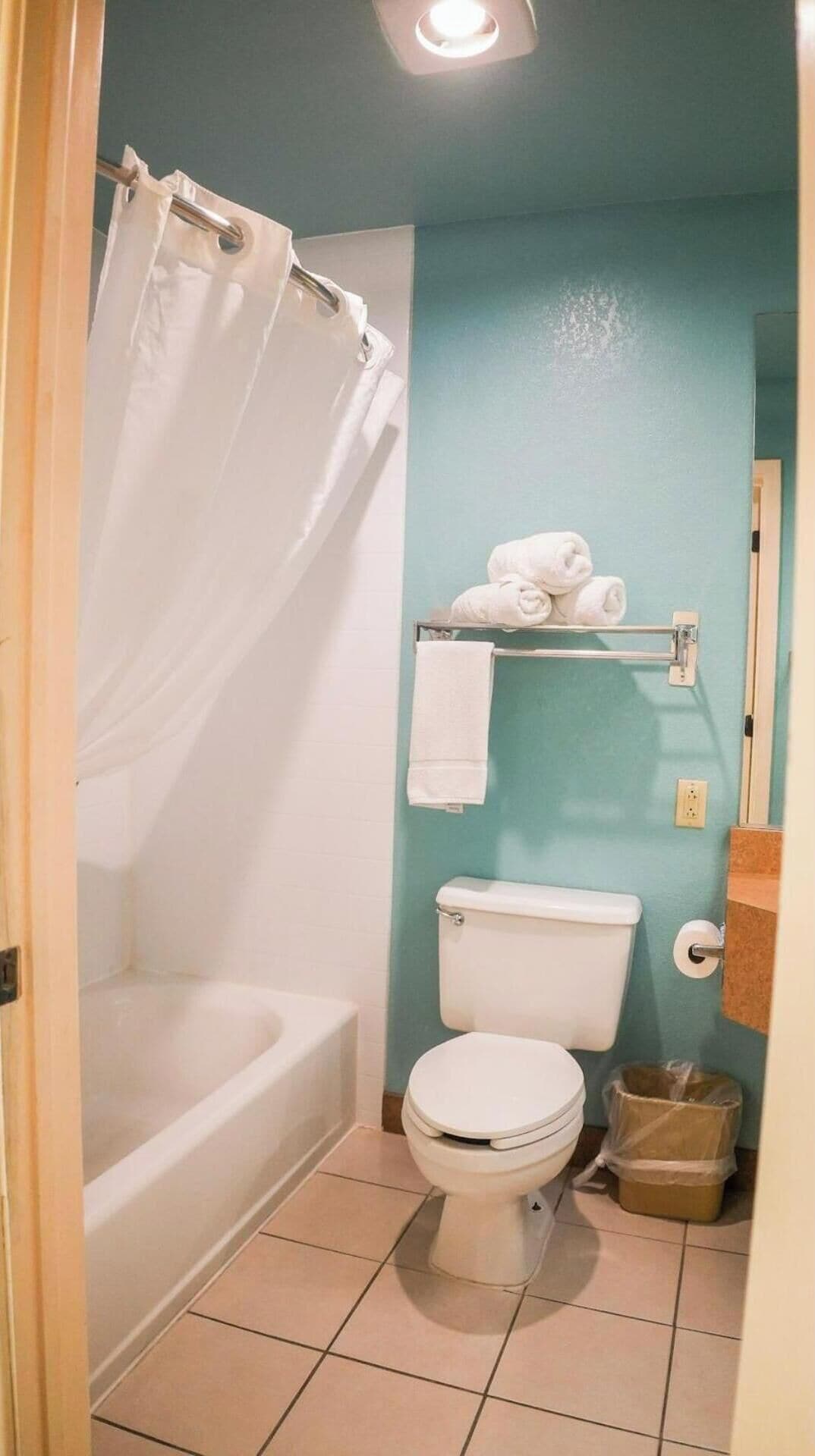 Un baño con bañera, inodoro y perchero.