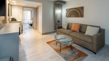 A modern living room with a sofa, a coffee table, and a flat-screen TV.