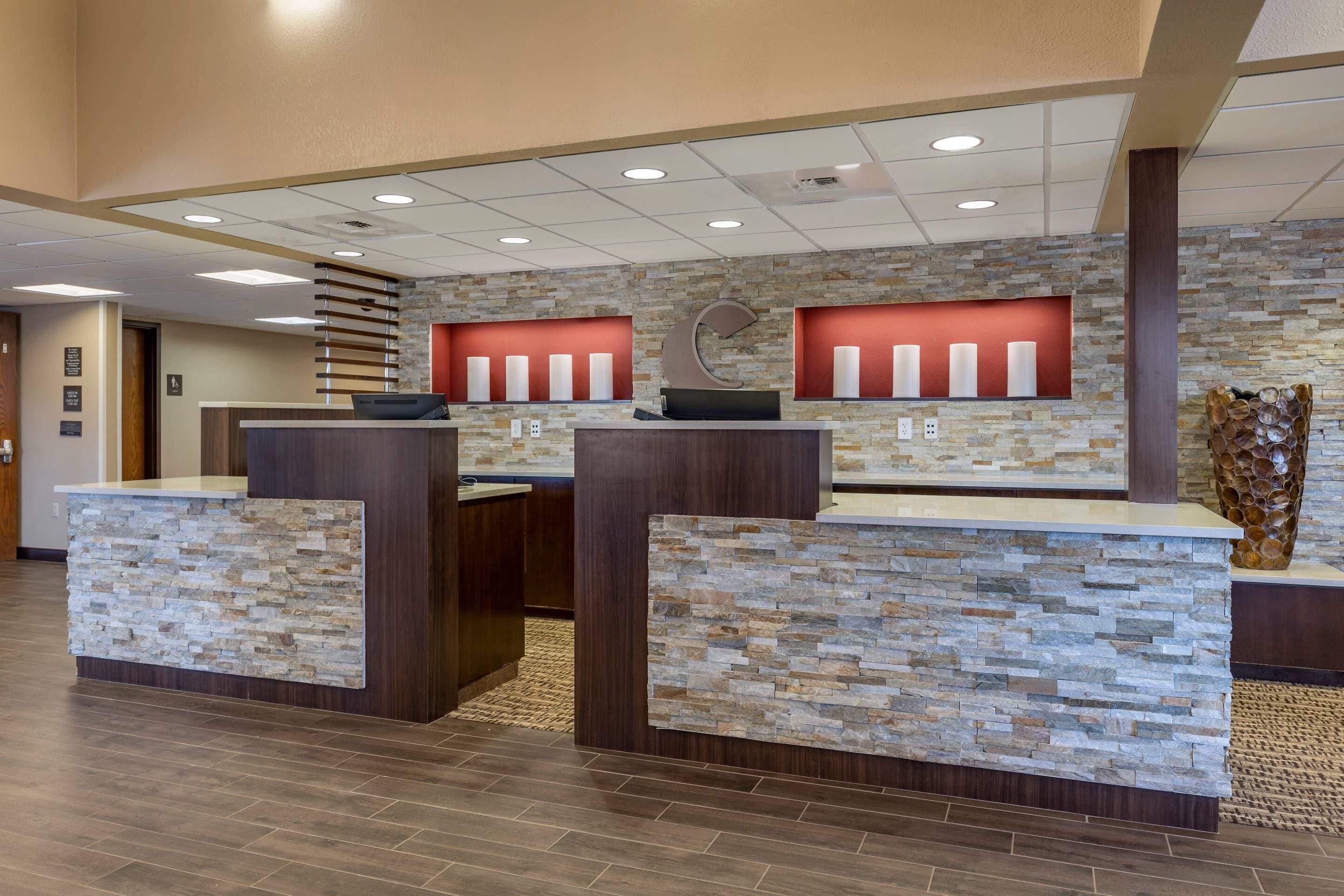A reception area with a stone wall, two counters, and a wooden reception desk.