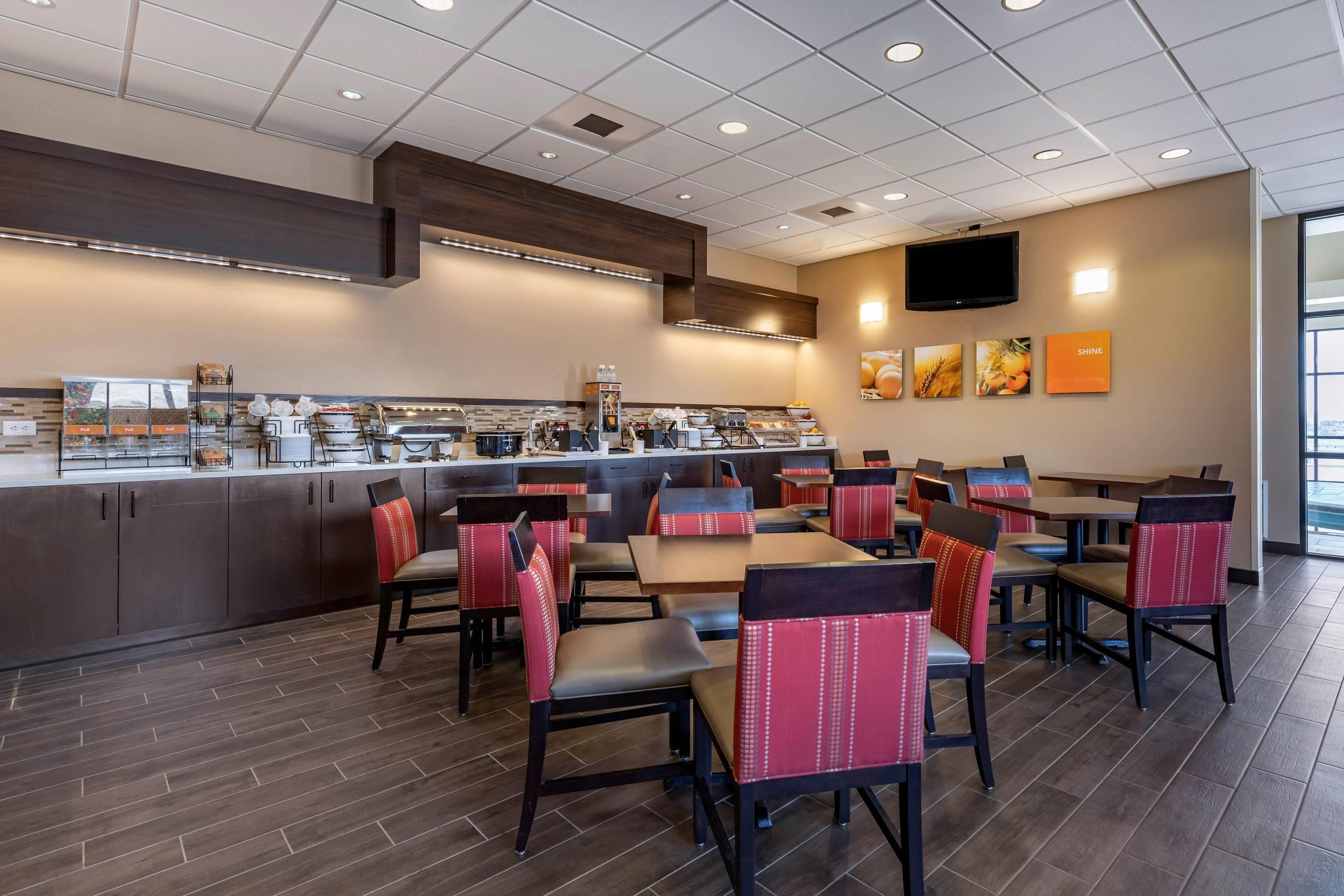 A restaurant with a counter, multiple tables, and chairs.