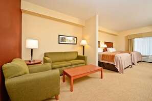 Relax in this stylish room with a green sofa, coffee table, and comfortable bed.