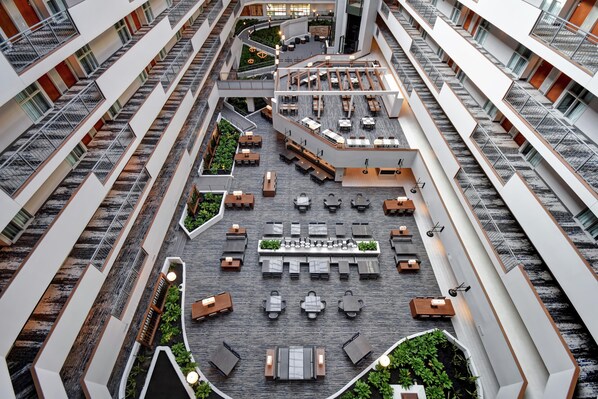 A multi-level atrium with outdoor seating areas, staircases, and a central garden. - Embassy Suites by Hilton Omaha Downtown Old Market (Omaha)
