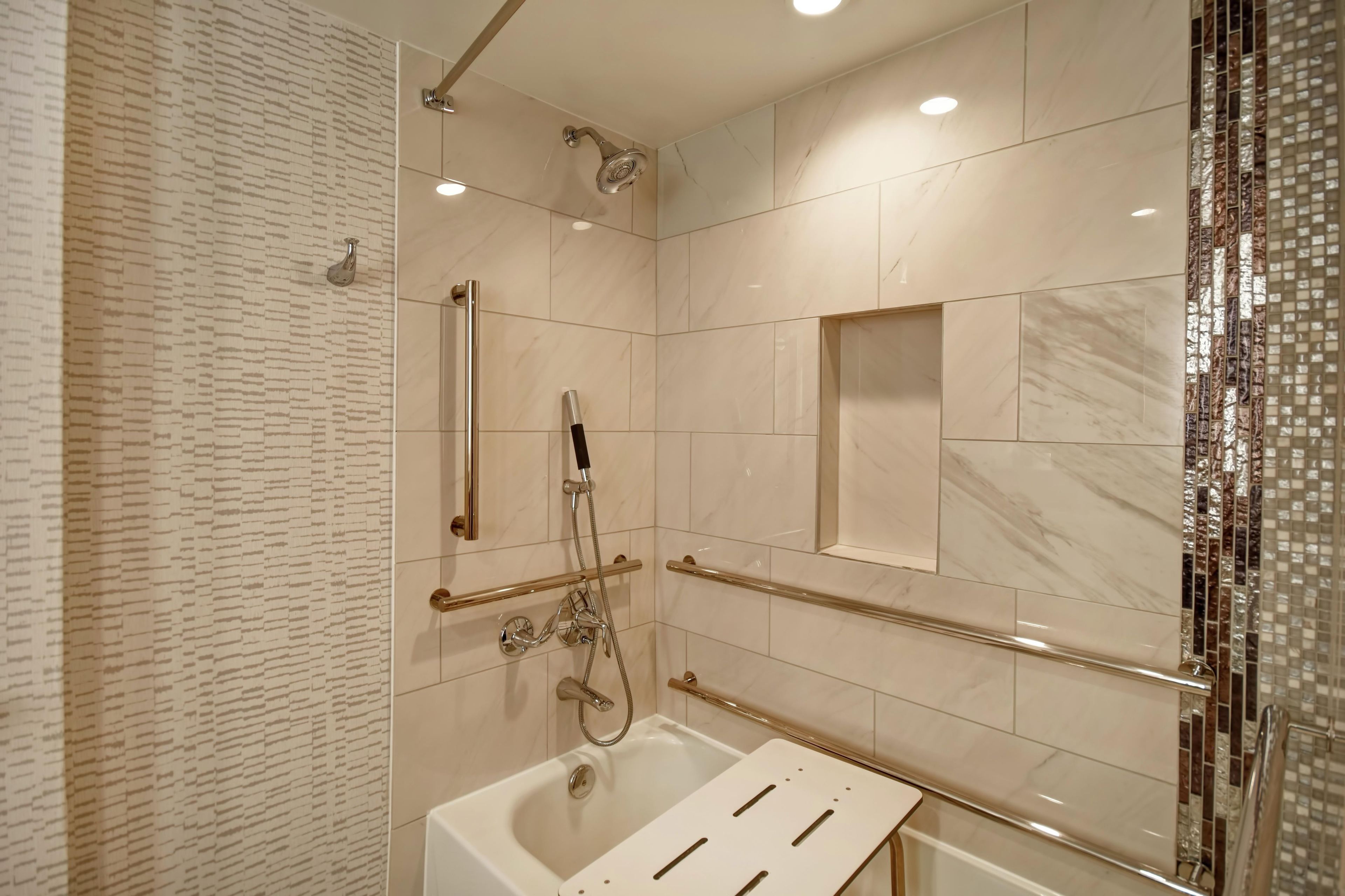 A modern bathroom with a walk-in shower, a bathtub, and a glass-enclosed shower area.