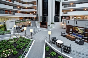 A multi-level hotel lobby with a central staircase, seating areas, and a bar/lounge area. - Embassy Suites by Hilton Omaha Downtown Old Market (Omaha)