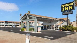 A motel with a covered parking area and a sign for the Economy Inn. - Economy Inn Barstow (Barstow)