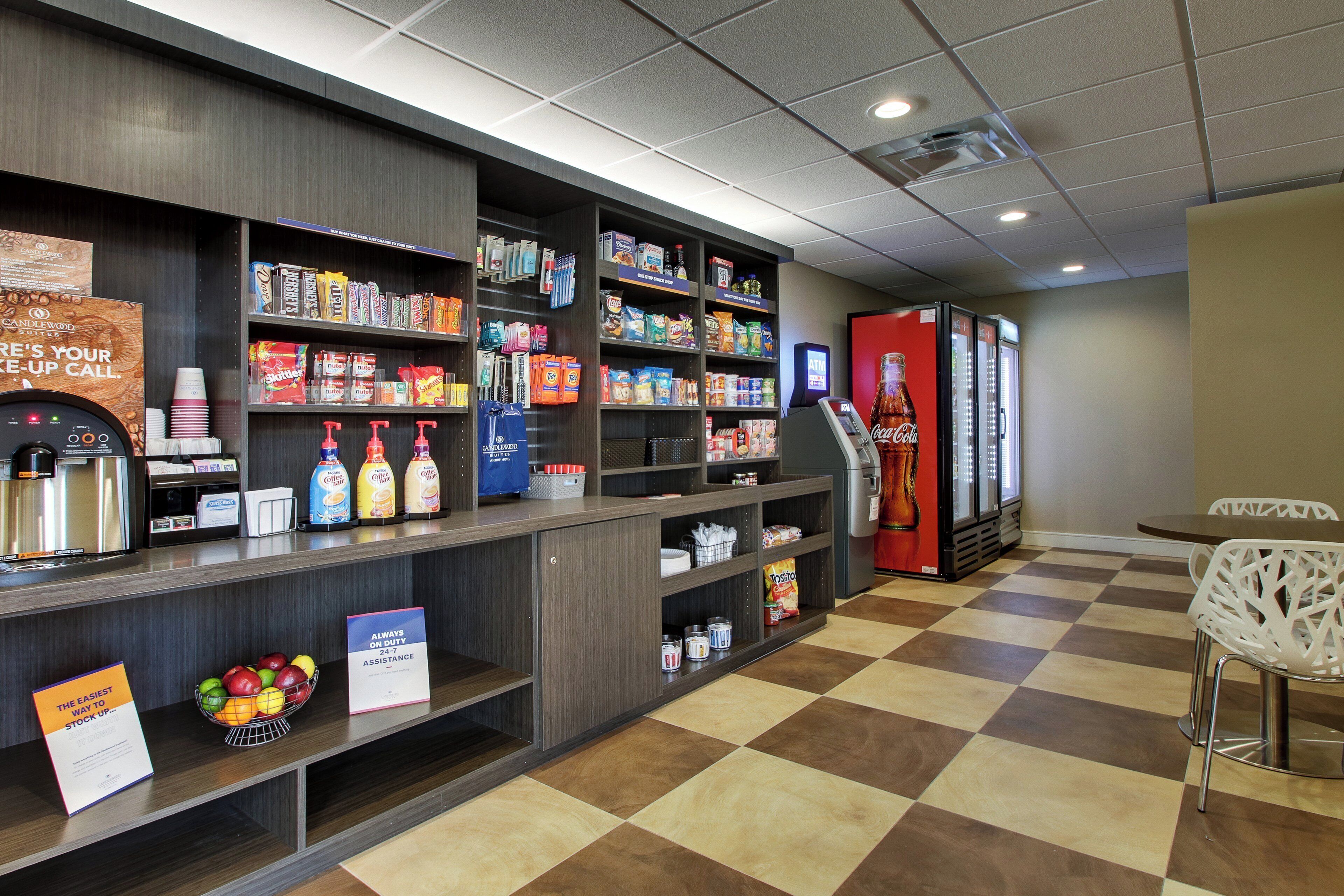 A self-service kiosk area with various snacks, beverages, and a Coca-Cola refrigerator.