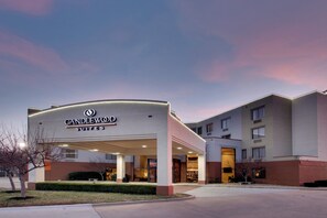A hotel entrance with a sign reading 'CANDLEWOOD SUITES'.