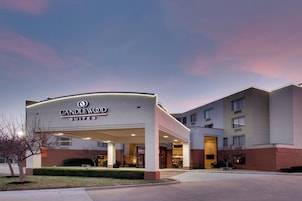 Entrada de un hotel con un cartel que dice 'CANDLEWOOD SUITES'.