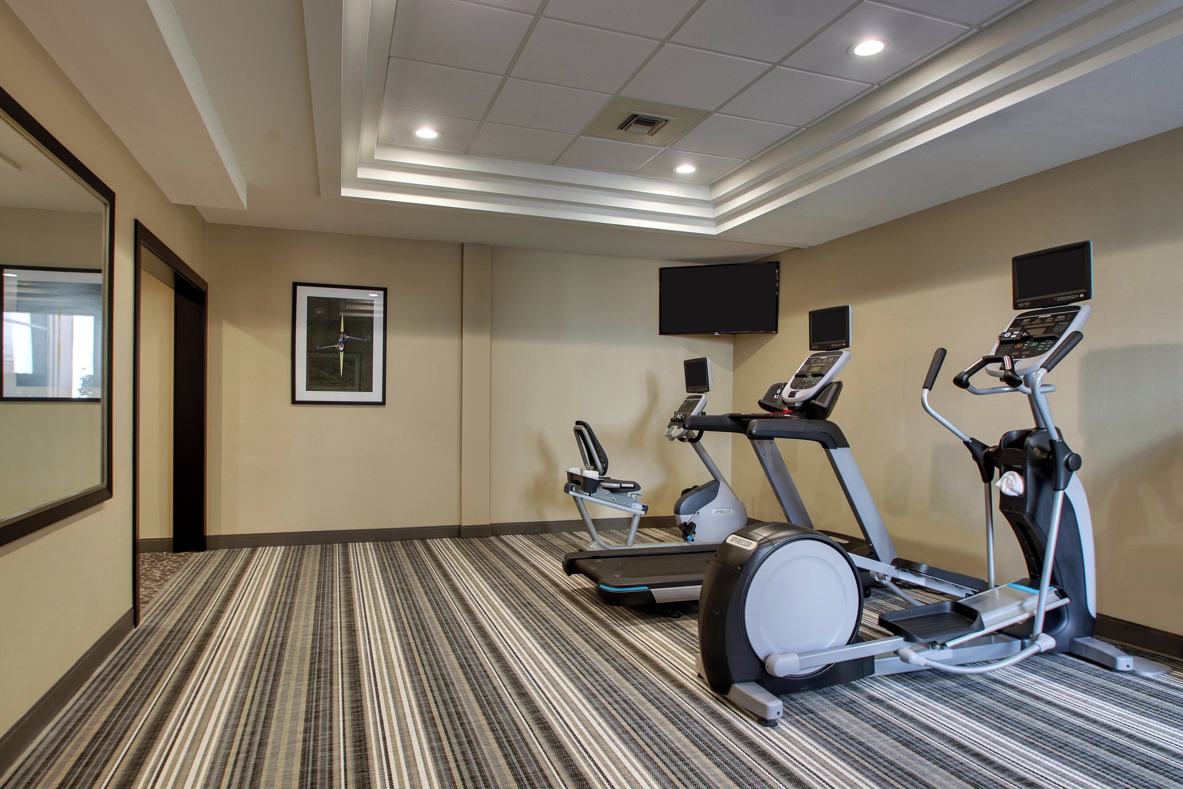 Una palestra alberghiera con tapis roulant, ellittiche e cyclette.