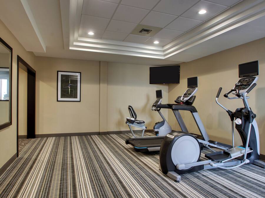 Una palestra alberghiera con tapis roulant, ellittiche e cyclette.