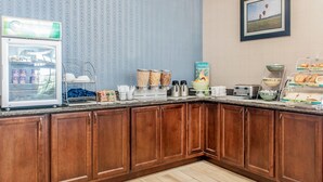 Un comptoir-repas équipé d’un réfrigérateur, de céréales et d’une sélection de cafés.